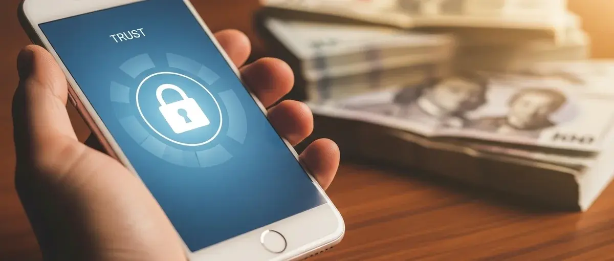 Hand using a secure mobile banking app for international financial transactions.